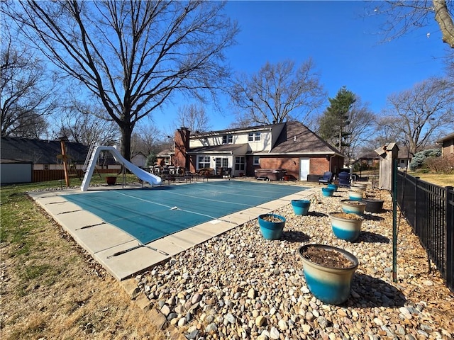 view of swimming pool with a patio area, a fenced in pool, a water slide, and a fenced backyard