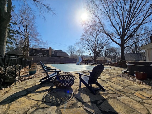 view of patio / terrace featuring a fenced in pool, a jacuzzi, a fire pit, and a fenced backyard