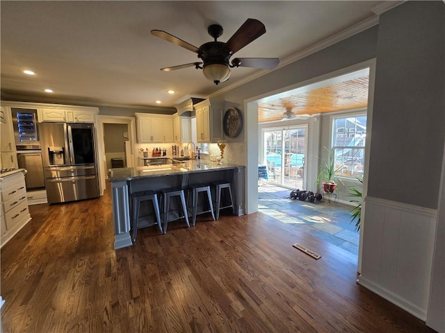 kitchen with visible vents, dark wood finished floors, a peninsula, appliances with stainless steel finishes, and white cabinets