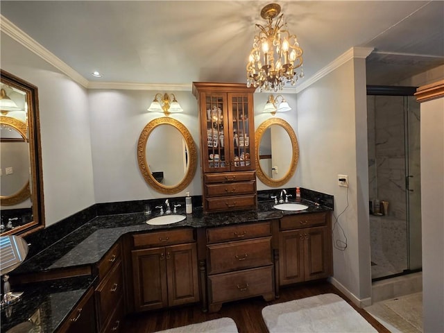 full bath with a shower stall, ornamental molding, and a sink