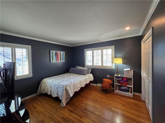 bedroom featuring crown molding, baseboards, and wood finished floors