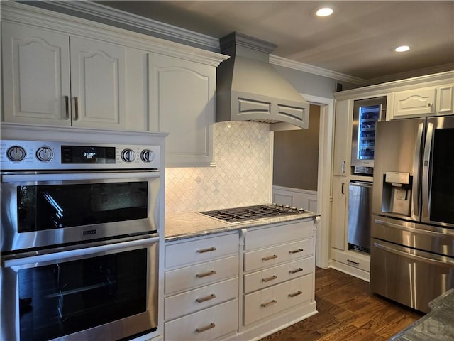 kitchen featuring dark wood finished floors, decorative backsplash, custom range hood, appliances with stainless steel finishes, and crown molding