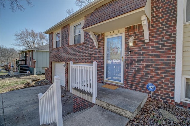 property entrance with brick siding and a garage