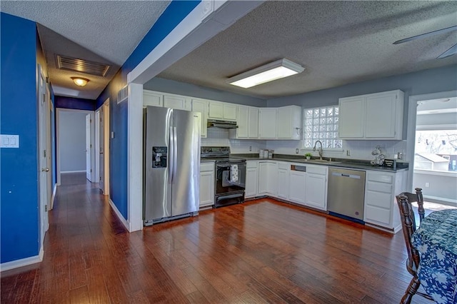 kitchen with under cabinet range hood, visible vents, appliances with stainless steel finishes, and dark wood-style floors