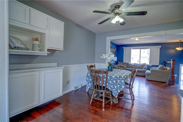 dining room featuring visible vents, dark wood-type flooring, a ceiling fan, and a textured ceiling