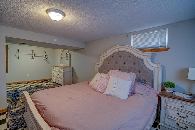 bedroom featuring tile patterned floors and a textured ceiling