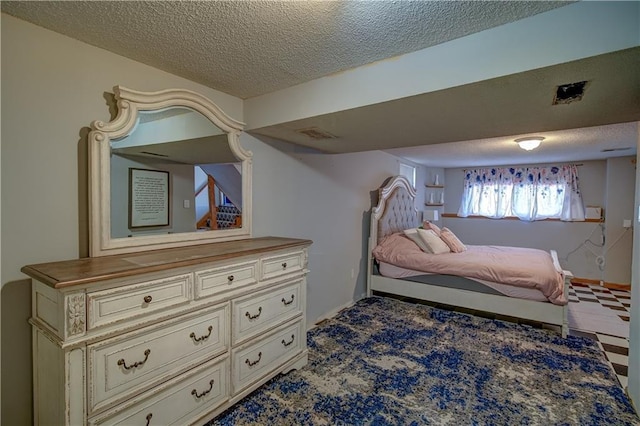 bedroom with baseboards, visible vents, and a textured ceiling