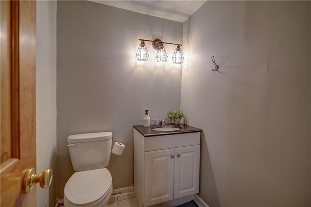 bathroom featuring baseboards, toilet, and vanity