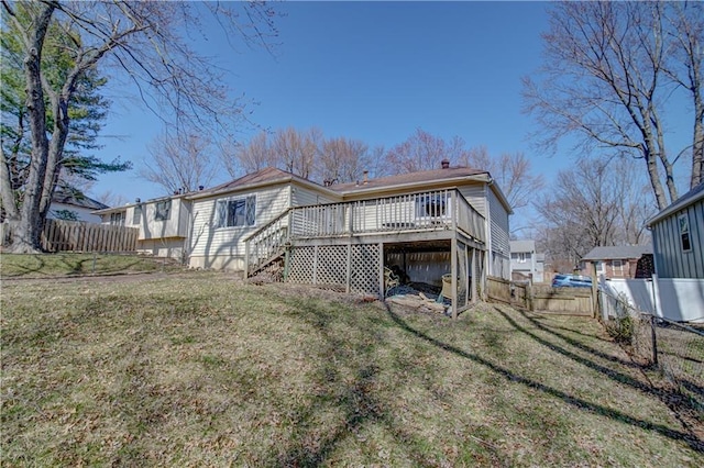 rear view of property featuring a wooden deck, a yard, a fenced backyard, and stairs