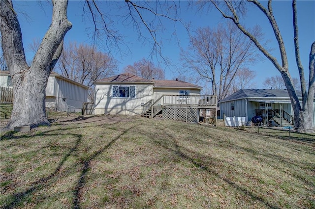 back of house with a wooden deck, a yard, and fence