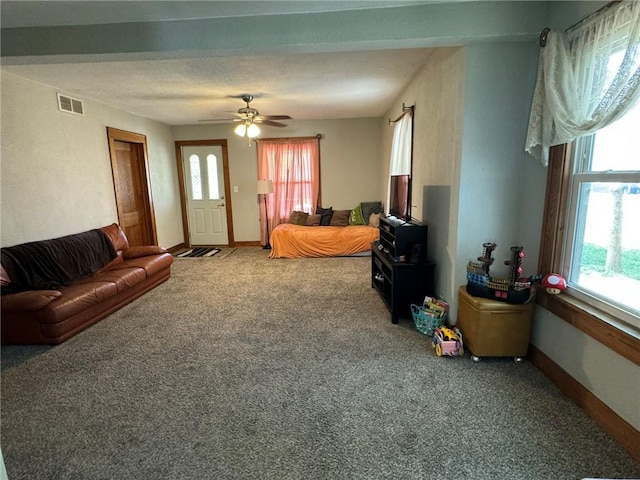 living room with ceiling fan, carpet, visible vents, and baseboards