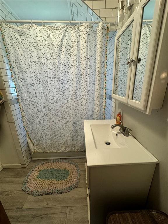 full bath featuring vanity, a shower stall, and wood finished floors