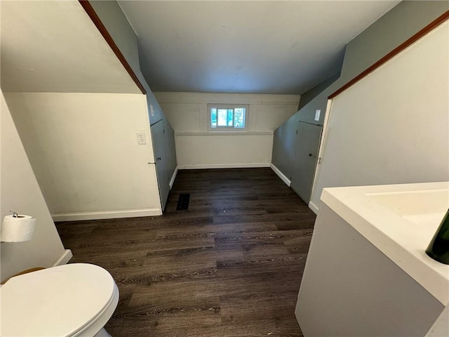 bathroom featuring toilet, wood finished floors, visible vents, and baseboards