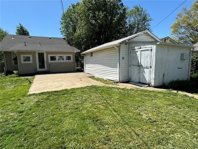 back of house featuring a yard, a shed, an outdoor structure, and a patio