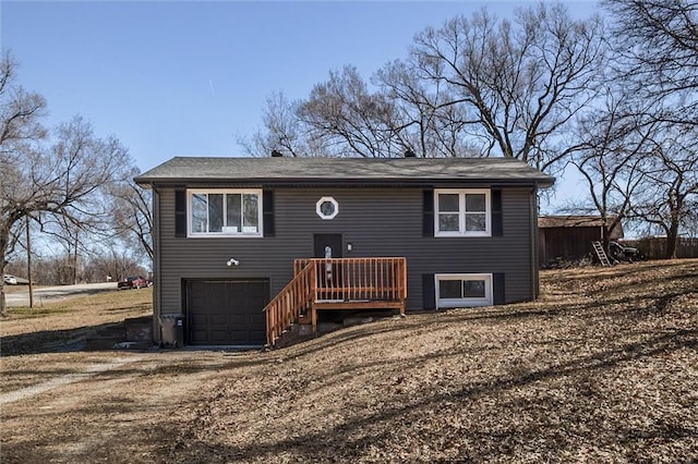 raised ranch with dirt driveway and an attached garage