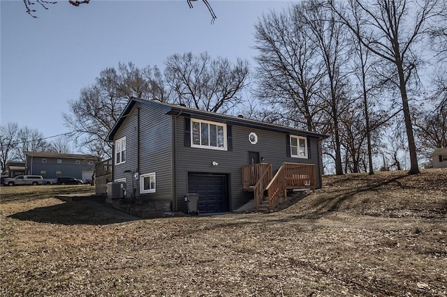 back of property featuring central AC unit and an attached garage