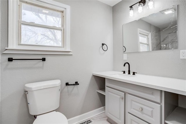 bathroom featuring baseboards, toilet, marble finish floor, and vanity