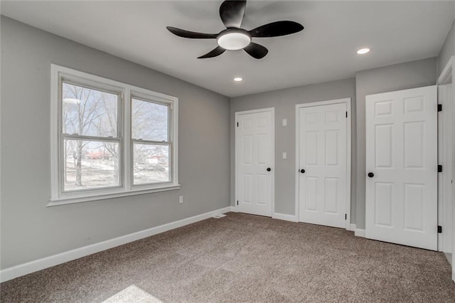 unfurnished bedroom with carpet, baseboards, recessed lighting, ceiling fan, and multiple closets