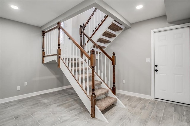 entrance foyer with stairway, baseboards, and wood tiled floor