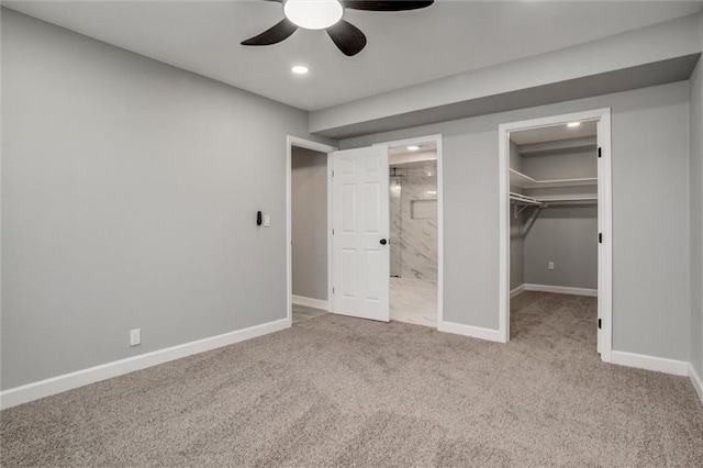 unfurnished bedroom with a walk in closet, ensuite bath, a closet, carpet floors, and baseboards