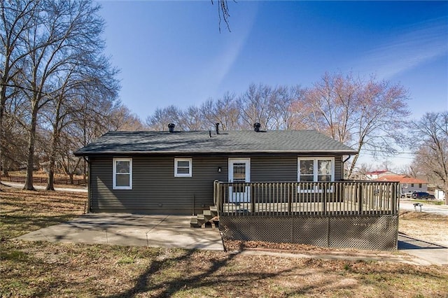 rear view of property with a wooden deck and a patio