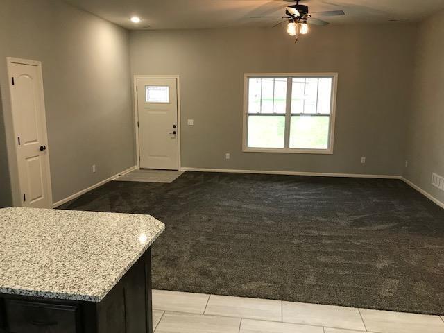 interior space featuring baseboards and a ceiling fan