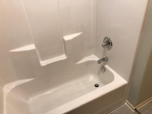 full bathroom featuring tile patterned flooring,  shower combination, and baseboards