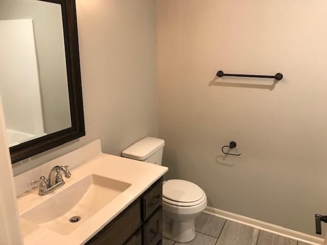 bathroom with vanity, toilet, and baseboards