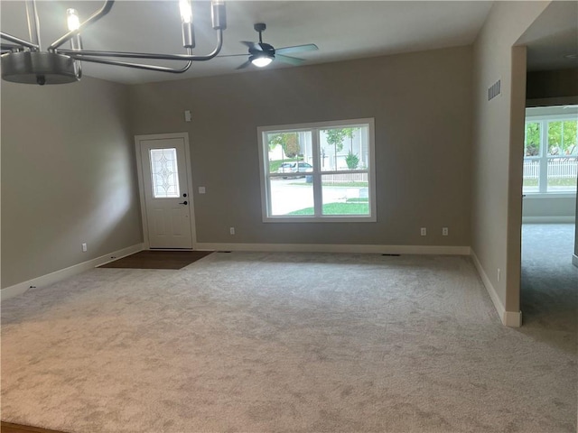 interior space with ceiling fan with notable chandelier, visible vents, carpet floors, and baseboards