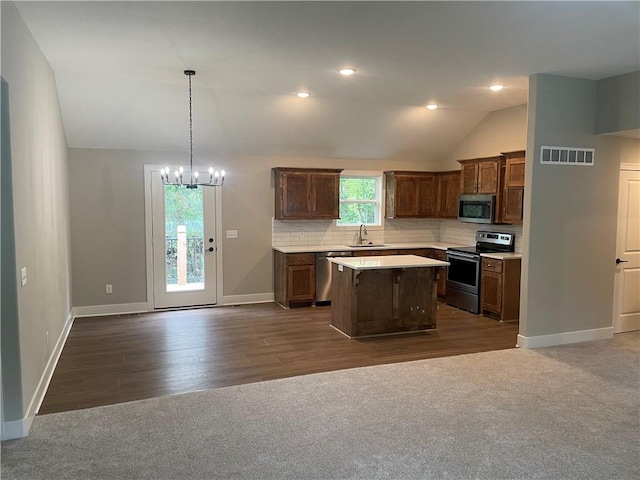 kitchen with visible vents, a chandelier, open floor plan, appliances with stainless steel finishes, and a sink