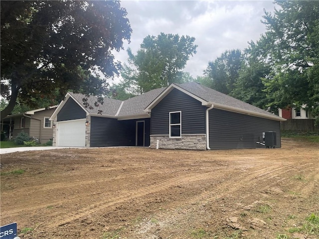 2101 N 31st Ter, Saint Joseph, MO 64506 - ranch-style house with stone siding, a garage, and driveway