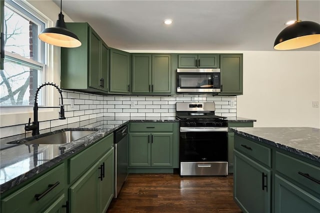 kitchen featuring dark wood finished floors, stainless steel appliances, green cabinets, and a sink