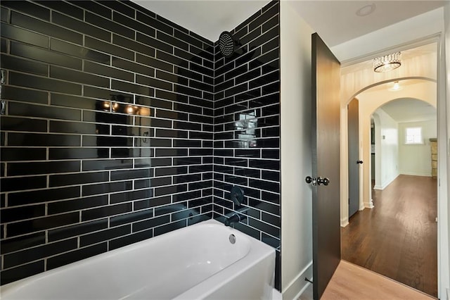 full bath featuring baseboards, wood finished floors, and bathtub / shower combination