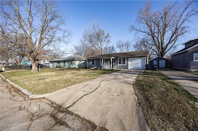 ranch-style home with a front yard, fence, covered porch, concrete driveway, and a garage