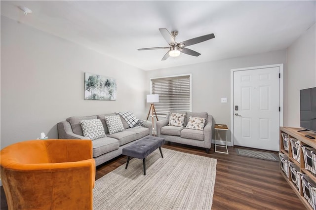 living room with baseboards, ceiling fan, and dark wood finished floors