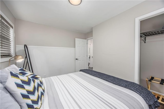 bedroom featuring a wainscoted wall