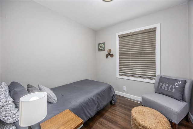 bedroom featuring wood finished floors, visible vents, and baseboards