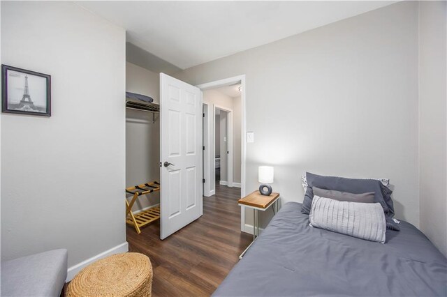 bedroom with baseboards and dark wood-style flooring