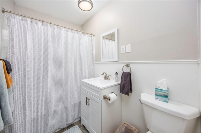 full bath featuring toilet, vanity, and a shower with curtain