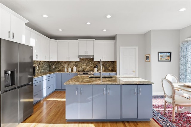 kitchen with white cabinetry, light wood-style floors, appliances with stainless steel finishes, and a sink