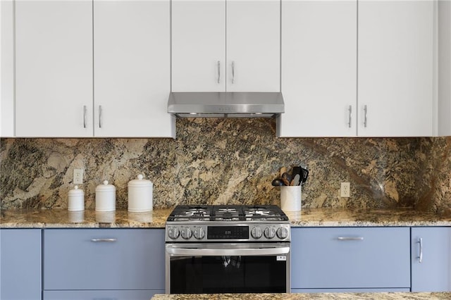 kitchen featuring stone countertops, gas range, under cabinet range hood, and white cabinetry