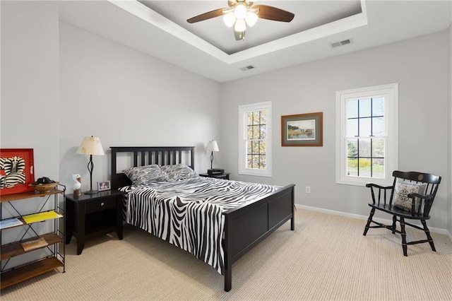 bedroom featuring a raised ceiling, visible vents, light carpet, and baseboards
