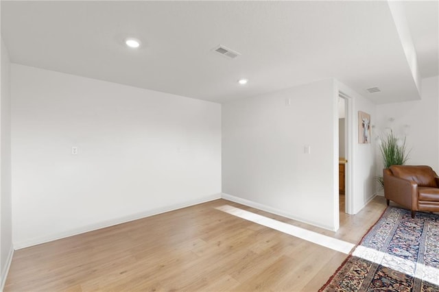unfurnished room featuring baseboards, visible vents, light wood-style floors, and recessed lighting