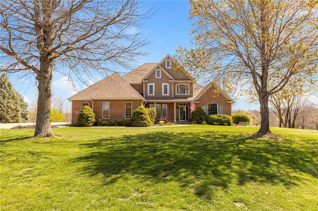 view of front of house featuring a front yard and brick siding