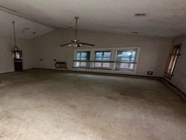 unfurnished living room featuring a ceiling fan and vaulted ceiling