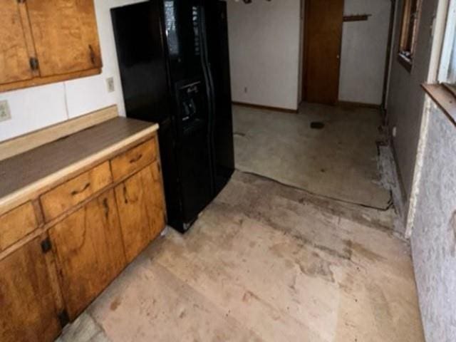 kitchen featuring black fridge with ice dispenser and brown cabinets