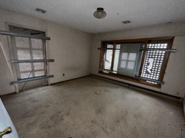 carpeted spare room featuring visible vents