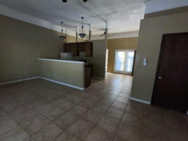 kitchen featuring open floor plan, decorative light fixtures, a ceiling fan, and baseboards