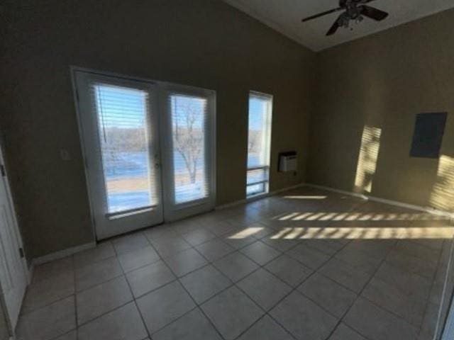 empty room featuring light tile patterned floors, baseboards, and ceiling fan