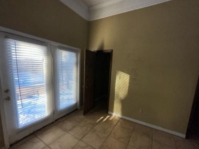 spare room with light tile patterned flooring and baseboards